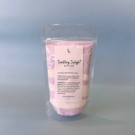 Pink bath fizz package with a label on a light blue background