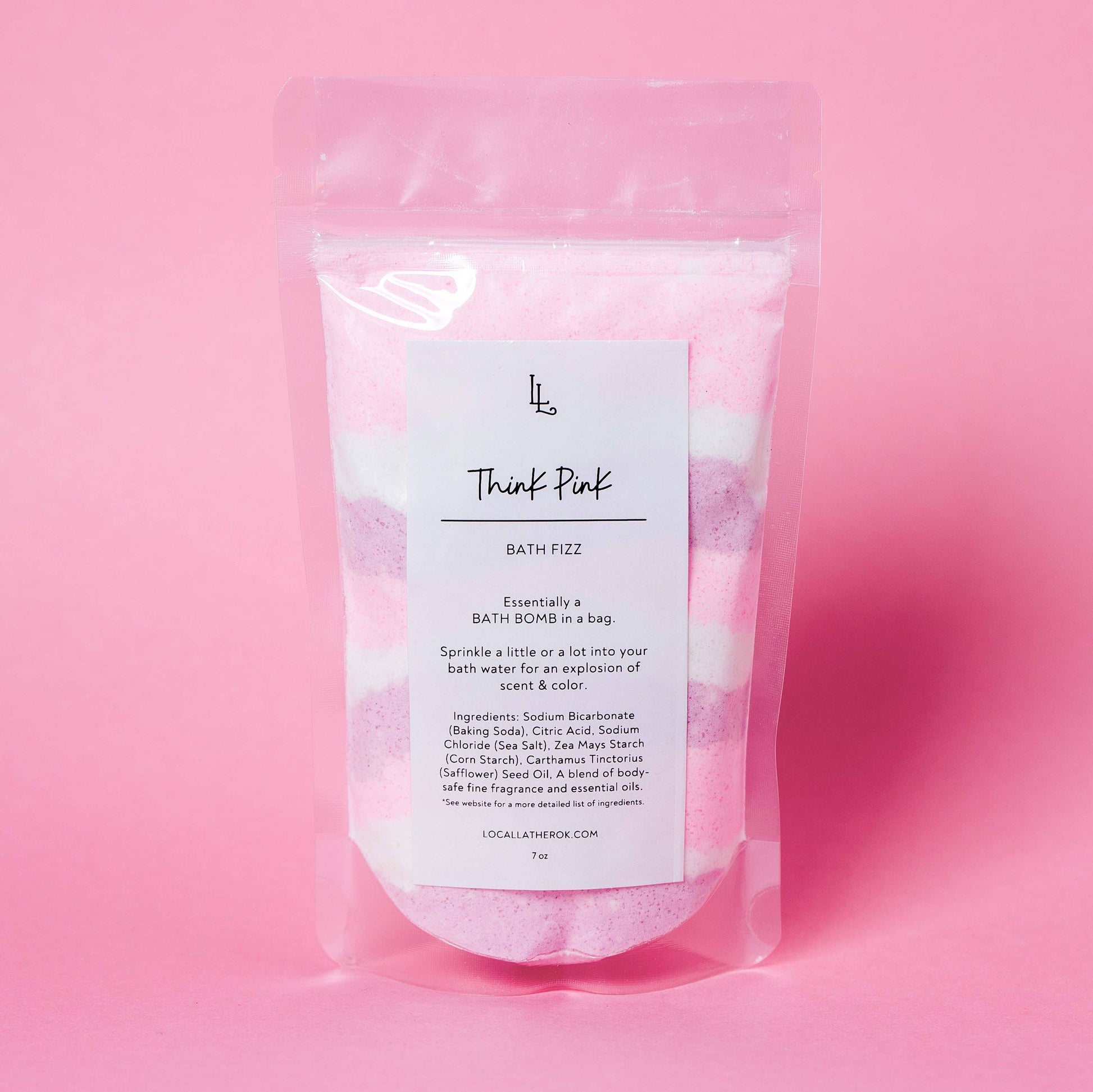 Packaged bath fizz with a pink gradient background