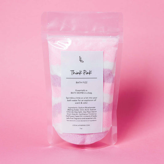 Packaged bath fizz with a pink gradient background