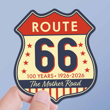 Sticker with Route 66 design held by a hand against a light blue background