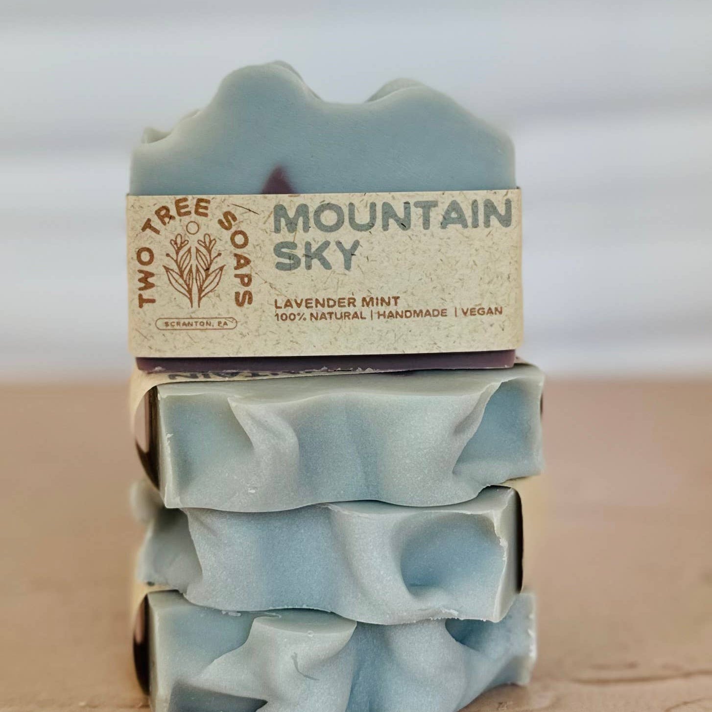 Stack of mountain sky soap bars with a visible label on a wooden surface
