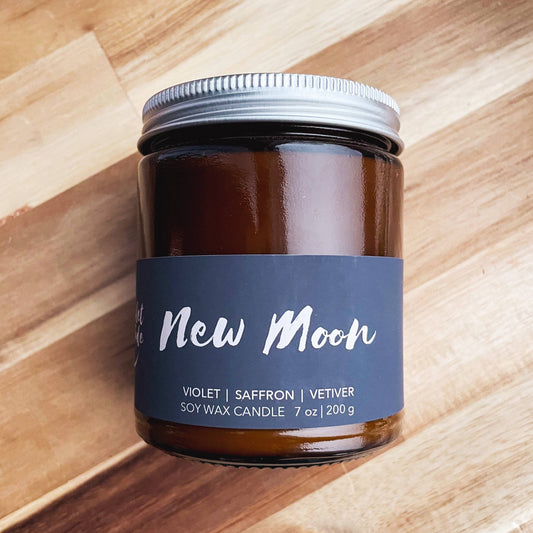 Candle jar with a blue label on a wooden surface