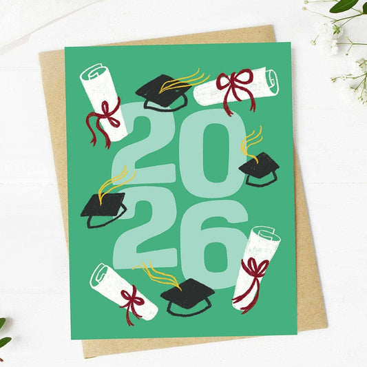 Graduation-themed card with '2026' on a green background, featuring mortarboards and scrolls.