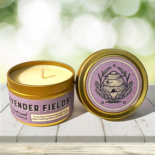 Lavender Fields candle in a gold tin with a purple label on a wooden surface.