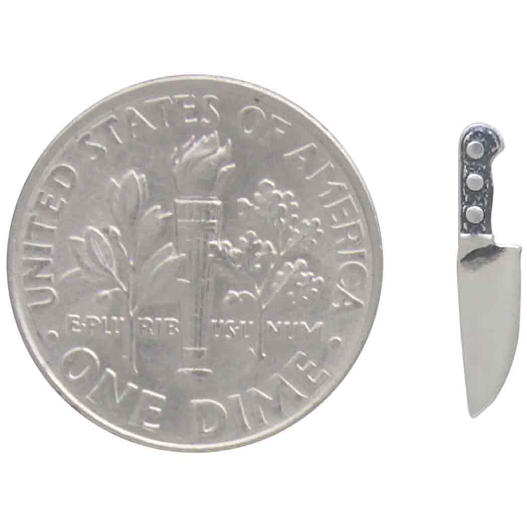 Silver U.S. dime coin with a knife on a white background