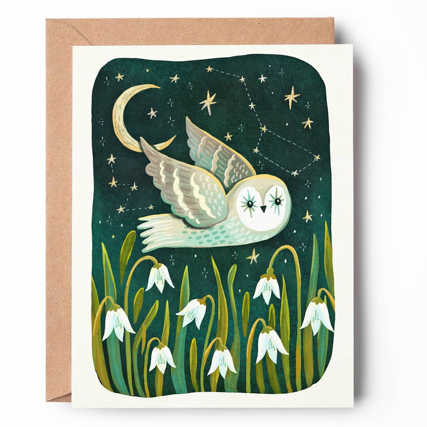 A square greeting card with a kraft envelope, featuring an illustration of a white owl flying at night under a crescent moon and stars, with snowdrop flowers at the bottom.
