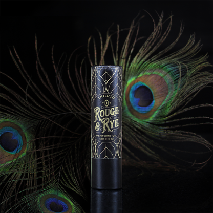 Perfume oil bottle with peacock feathers on a dark background