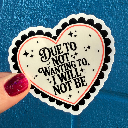 Heart-shaped sticker with text held by a hand against a blue background
