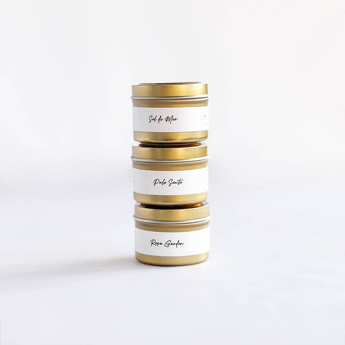 Stack of cylindrical tins with gold accents on a white background
