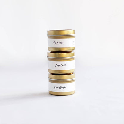 Stack of cylindrical tins with gold accents on a white background
