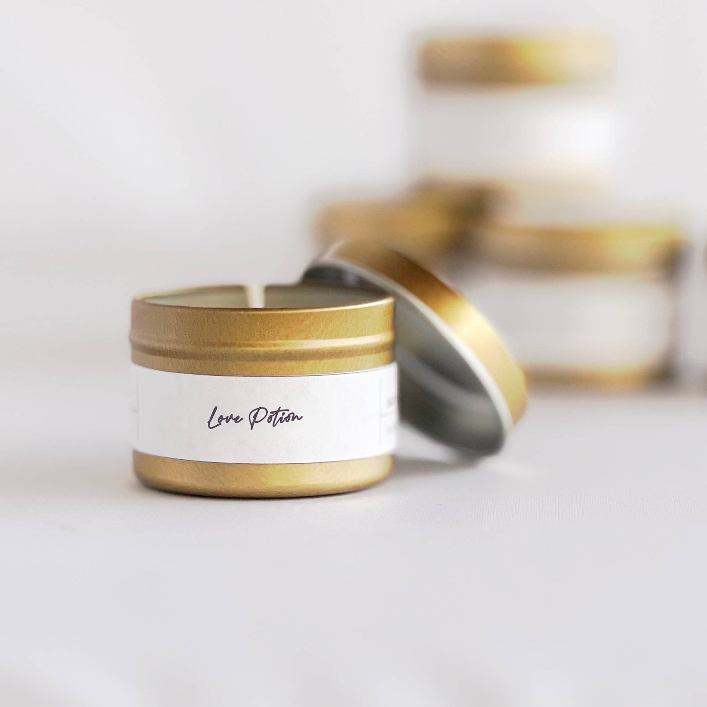 Candle with gold lid and white label on a light background