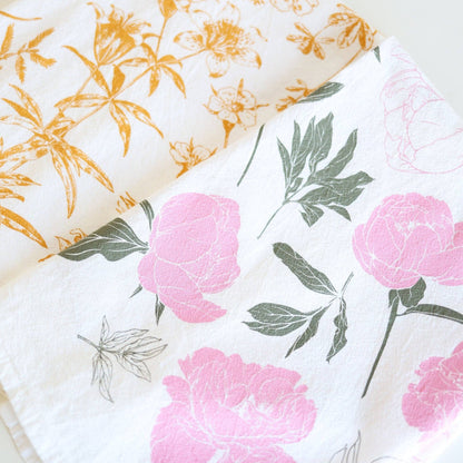 Two floral-patterned cloths with pink flowers and green leaves on a white background.