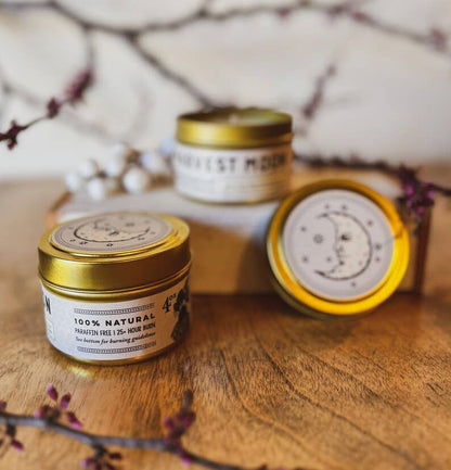 Three small jars with gold lids on a wooden surface with a blurred natural background