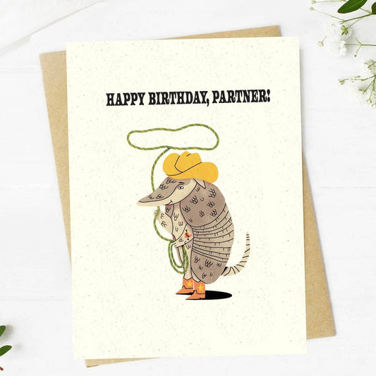 Birthday card with an illustration of an armadillo wearing a cowboy hat and boots, with 'Happy Birthday, Partner!' text.