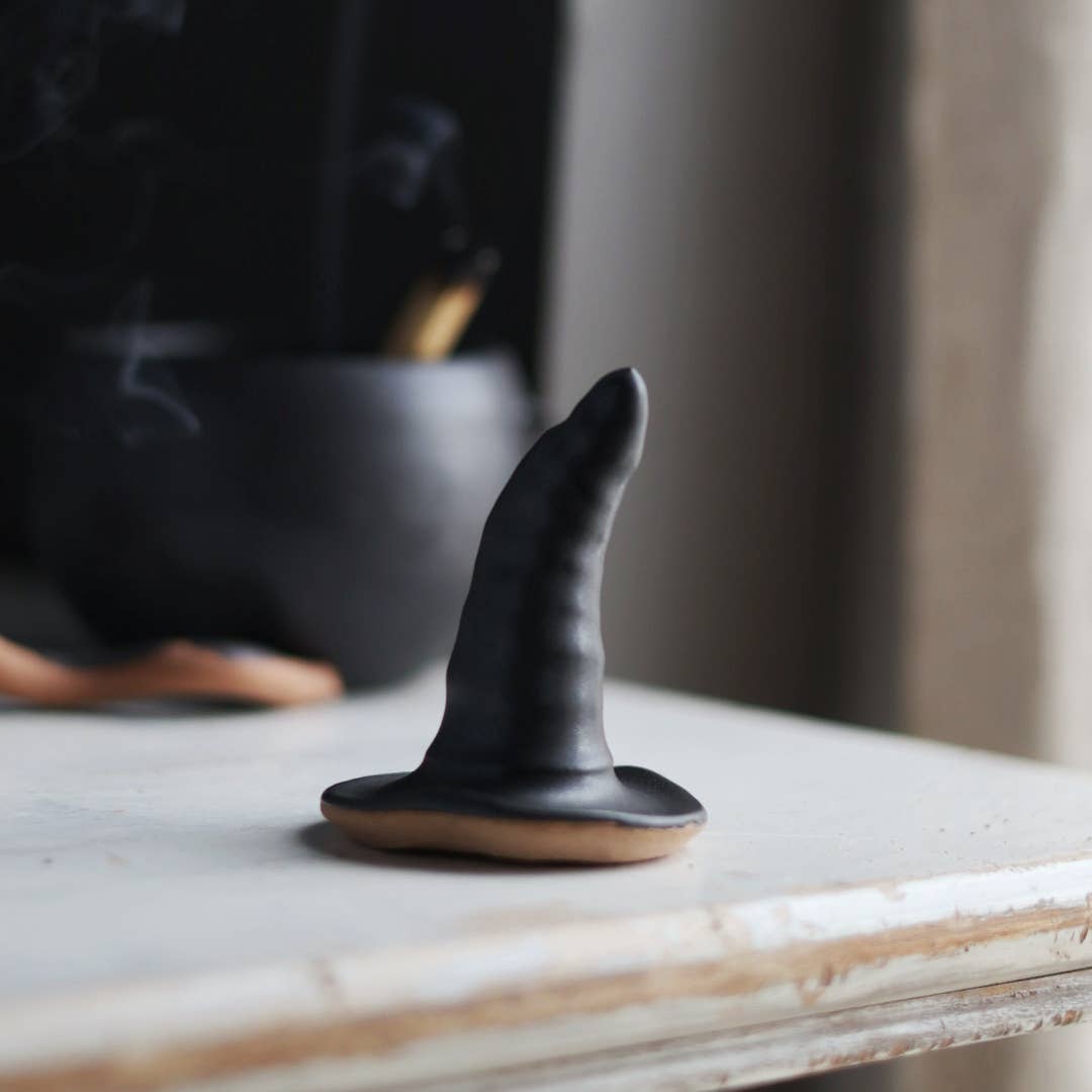 Black ceramic witch hat on smooth surface
