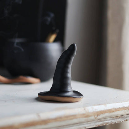 Black ceramic witch hat on smooth surface
