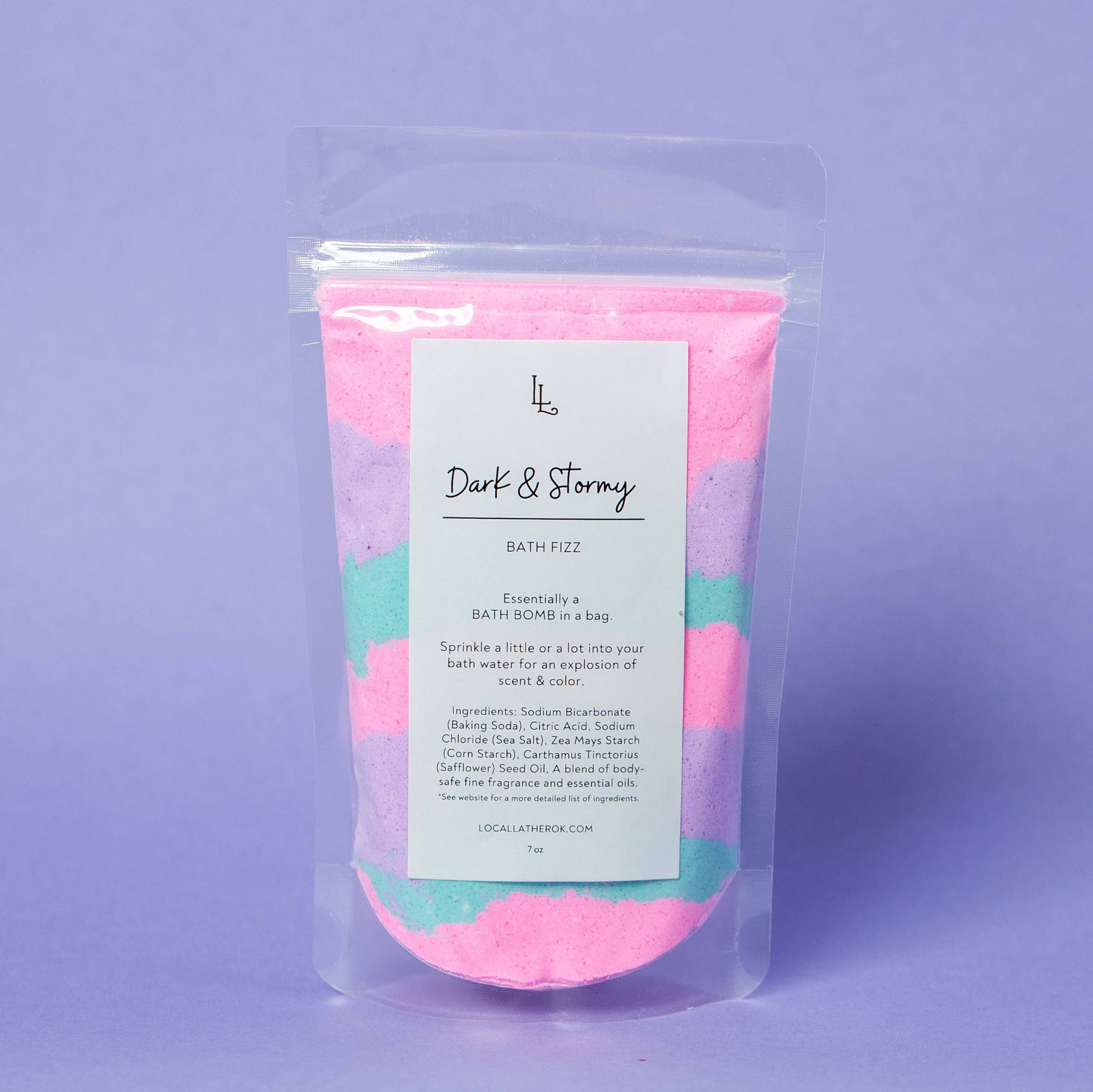 Packaged bath fizz with colorful crystals on a purple background