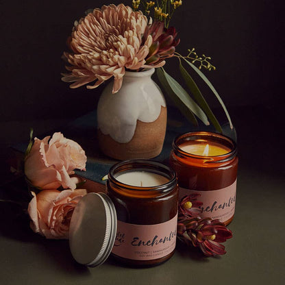 Two candles with floral arrangements on a dark background